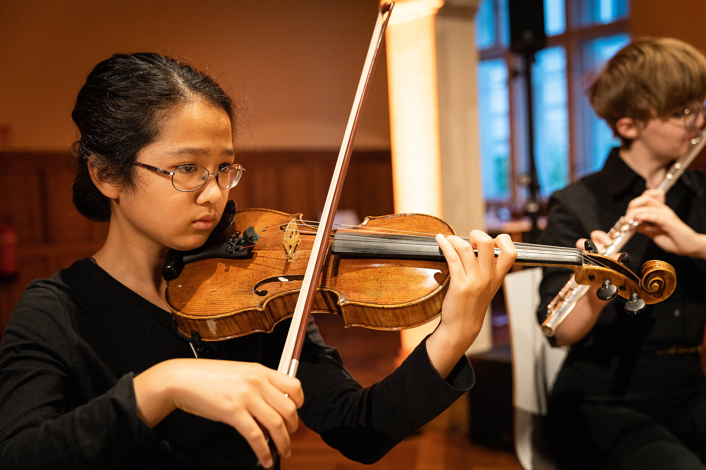 Das Bild zeigt eine junge Violonistin beim spielen, während der Konzertaufführung
